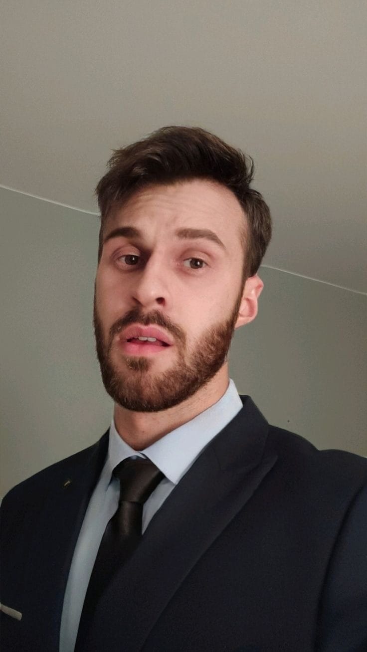 Чоловік у костюмі з густою бородою, прагне до зростання волосся.